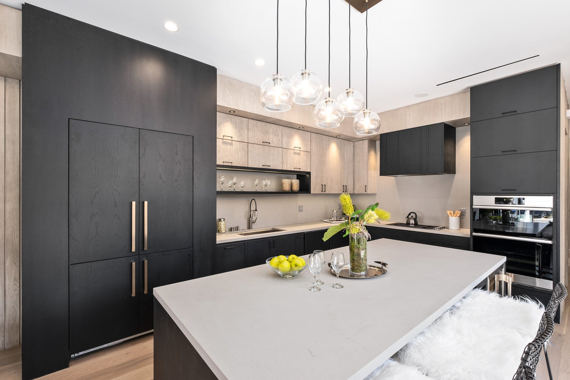 Kitchen with tall dark cabinetry and a pale island