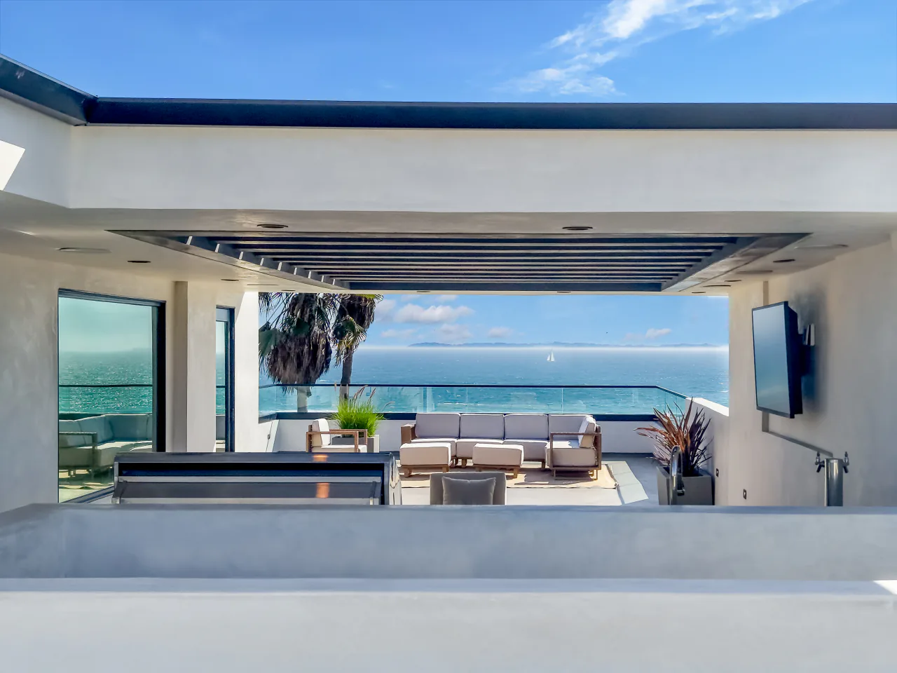 Ocean-facing rooftop terrace framed by open architectural beams